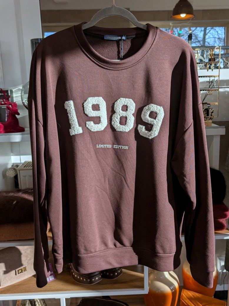 Das Sweatshirt 1989 in Kaffeebraun vereint zeitlosen Stil mit angenehmem Tragekomfort - natürliche Materialien und ein Design, das nie aus der Mode kommt!