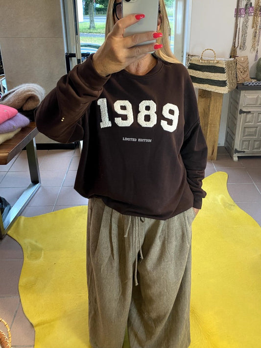 Das Sweatshirt 1989 in Kaffeebraun vereint zeitlosen Stil mit angenehmem Tragekomfort - natürliche Materialien und ein Design, das nie aus der Mode kommt!