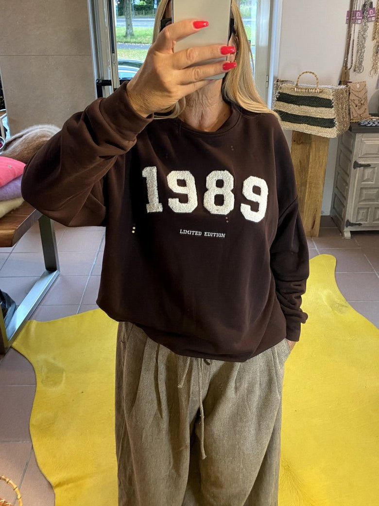 Das Sweatshirt 1989 in Kaffeebraun vereint zeitlosen Stil mit angenehmem Tragekomfort - natürliche Materialien und ein Design, das nie aus der Mode kommt!