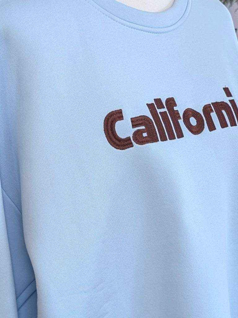 Das hochwertige Baumwoll-Sweatshirt California besticht durch seine harmonische Farbgestaltung in trendigem Hellblau und Coffee Braun - dein perfekten Begleiter!