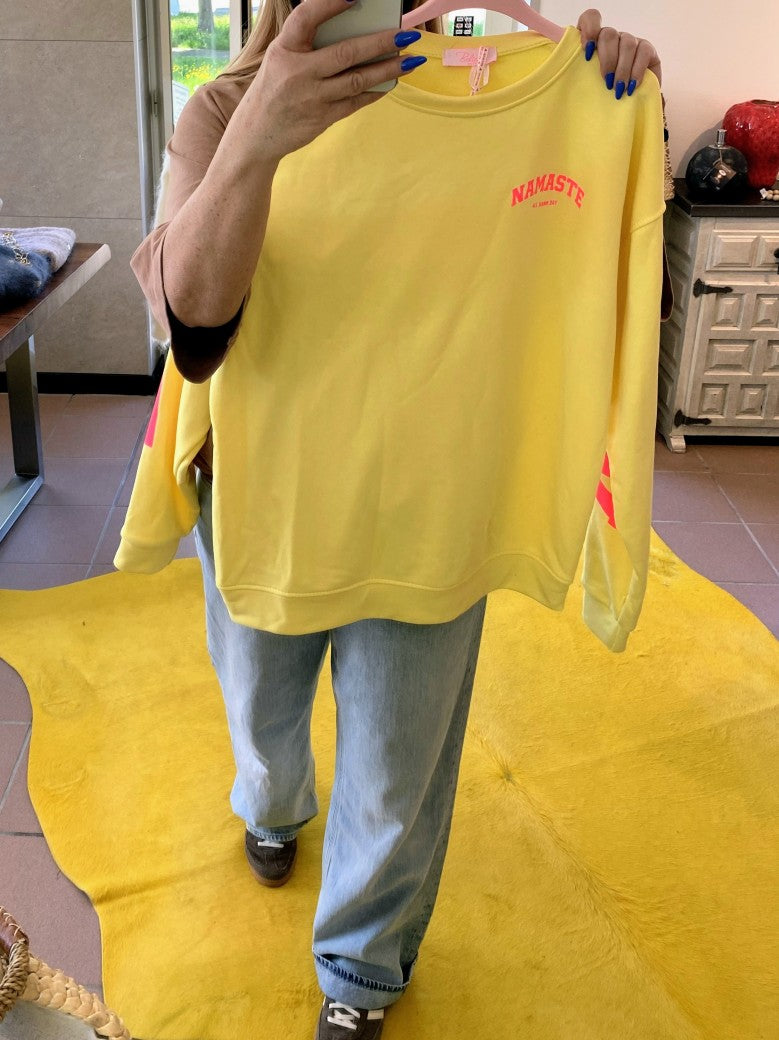 Das Sweatshirt Namaste von BELIEVE in Gelb mit auffälligem Backprint in Neon Pink bietet stilvollen Komfort und ist perfekt für einen lässigen Look.