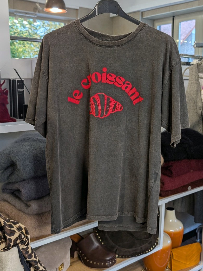 Das T-Shirt vereint Komfort und Stil perfekt: Hochwertige weiche Baumwolle und anthrazitfarbener Grundton mit lebhaftem Neon-Pink-Croissant-Design!