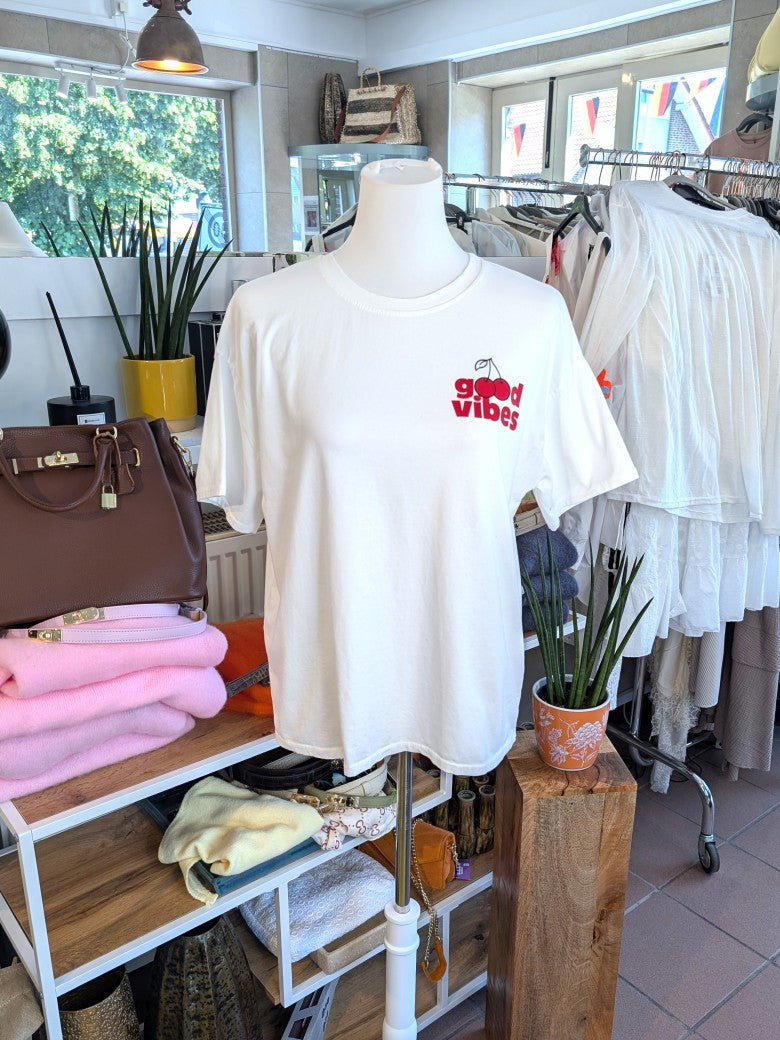 Lässiges T-Shirt in hellem Créme mit farbenfrohem Kirsch-Backprint in Rot, Gelb, Grün und Orange. Statement-Piece von Mioni für gute Laune und positive Energie.