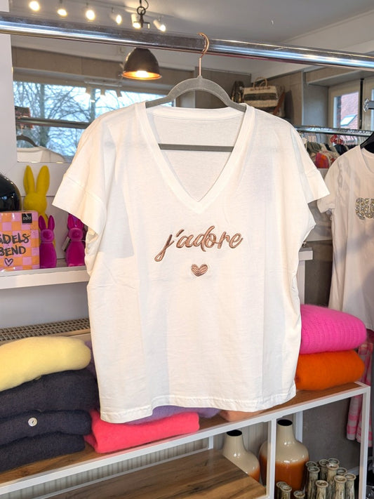 Das stylische T-Shirt J'Adore in Weiß mit Schriftzug in Roségold ist der perfekte Sommer-Look-Hingucker – vom lässigen Stadtbummel bis zum eleganten Abend-Outfit!
