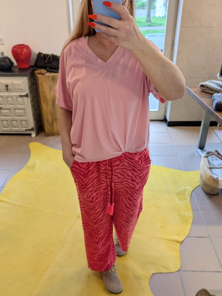 Entdecke die wilde Seite in dir mit unserer Zebra Muster Hose in leuchtendem Rot Rosa von BELIEVE. Dazu unser T-Shirt Pink mit V-Ausschnitt.