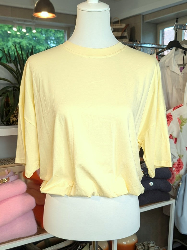 Weiches cropped Baumwoll-T-Shirt in zartem Butter-Gelb von Mioni Italien - perfekt für einen entspannten Look. Vielseitig kombinierbar und zeitlos elegant.