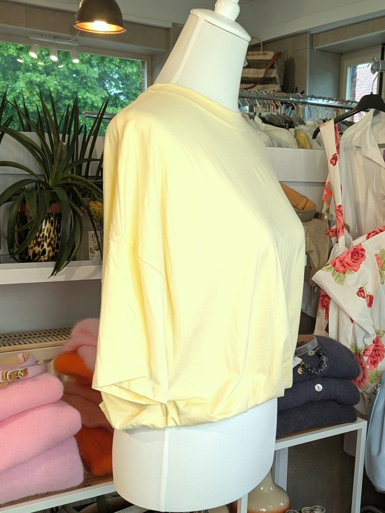 Weiches cropped Baumwoll-T-Shirt in zartem Butter-Gelb von Mioni Italien - perfekt für einen entspannten Look. Vielseitig kombinierbar und zeitlos elegant.