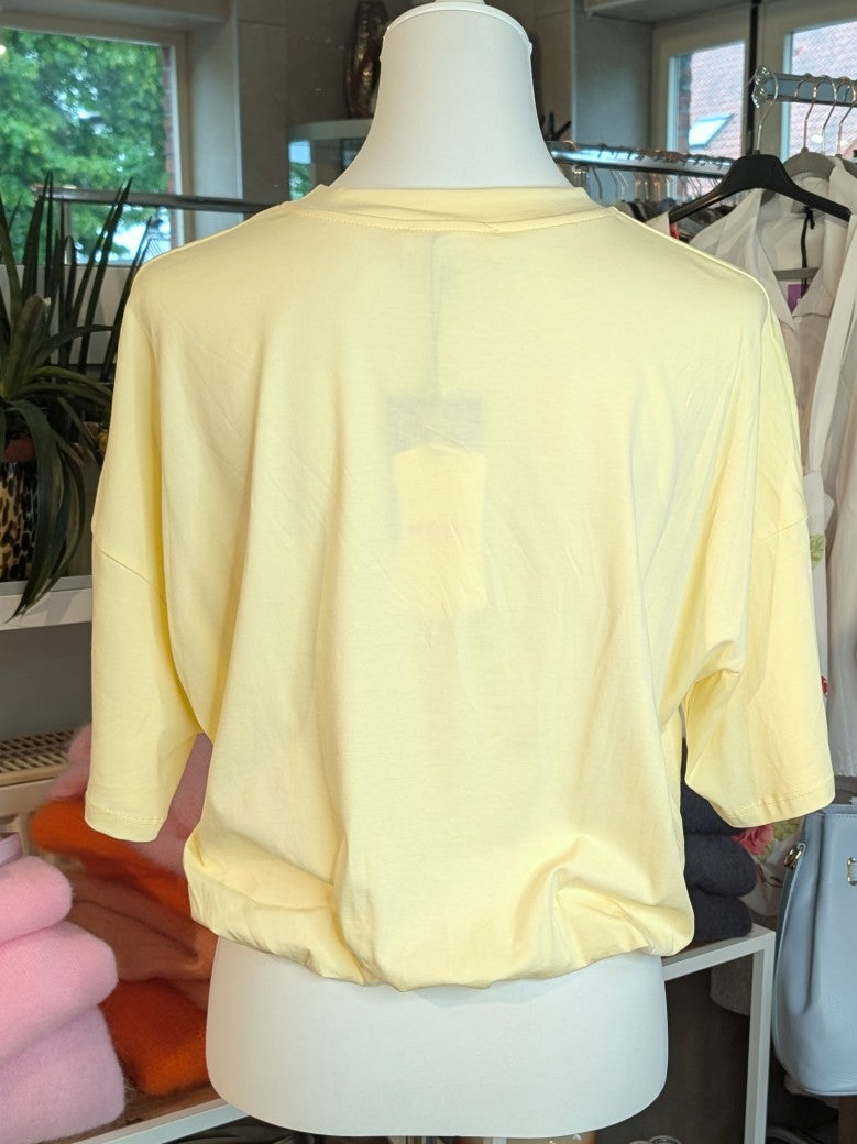 Weiches cropped Baumwoll-T-Shirt in zartem Butter-Gelb von Mioni Italien - perfekt für einen entspannten Look. Vielseitig kombinierbar und zeitlos elegant.