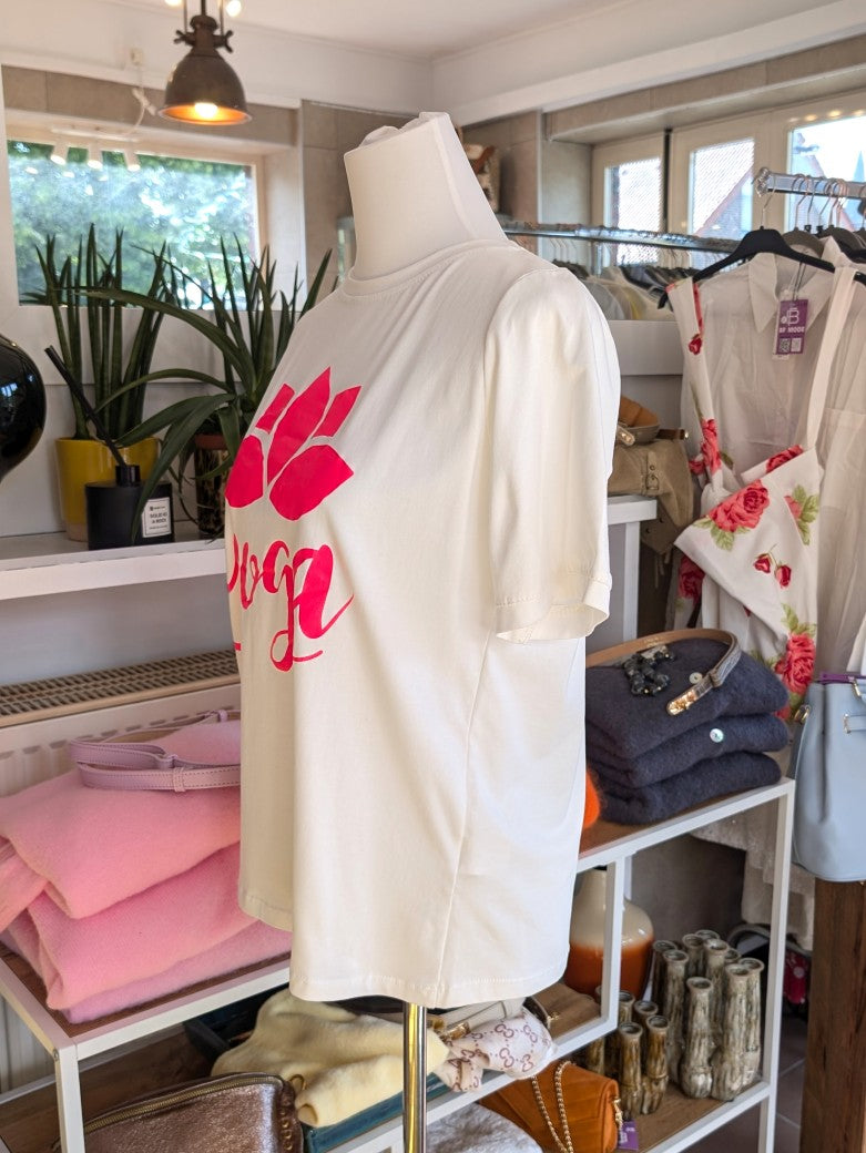 Das T-Shirt in Créme mit leuchtendem Pink aus hochwertiger Baumwolle ist perfekt für Yoga und Alltag - setze ein modisches Statement und fühle dich wohl!