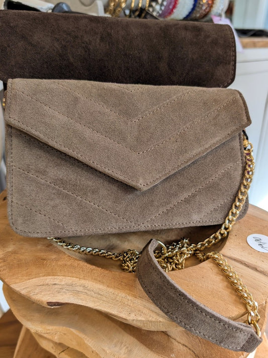 Diese elegante Handtasche aus hochwertigem Wildleder in zeitlosem Taupe vereint Stil und Funktionalität mit luxuriösen zeitlosen Akzenten. Cross-Body tragbar!