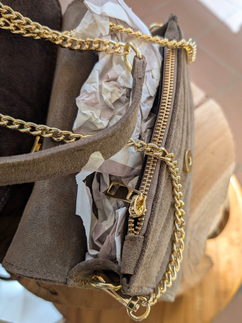 Diese elegante Handtasche aus hochwertigem Wildleder in zeitlosem Taupe vereint Stil und Funktionalität mit luxuriösen zeitlosen Akzenten. Cross-Body tragbar!