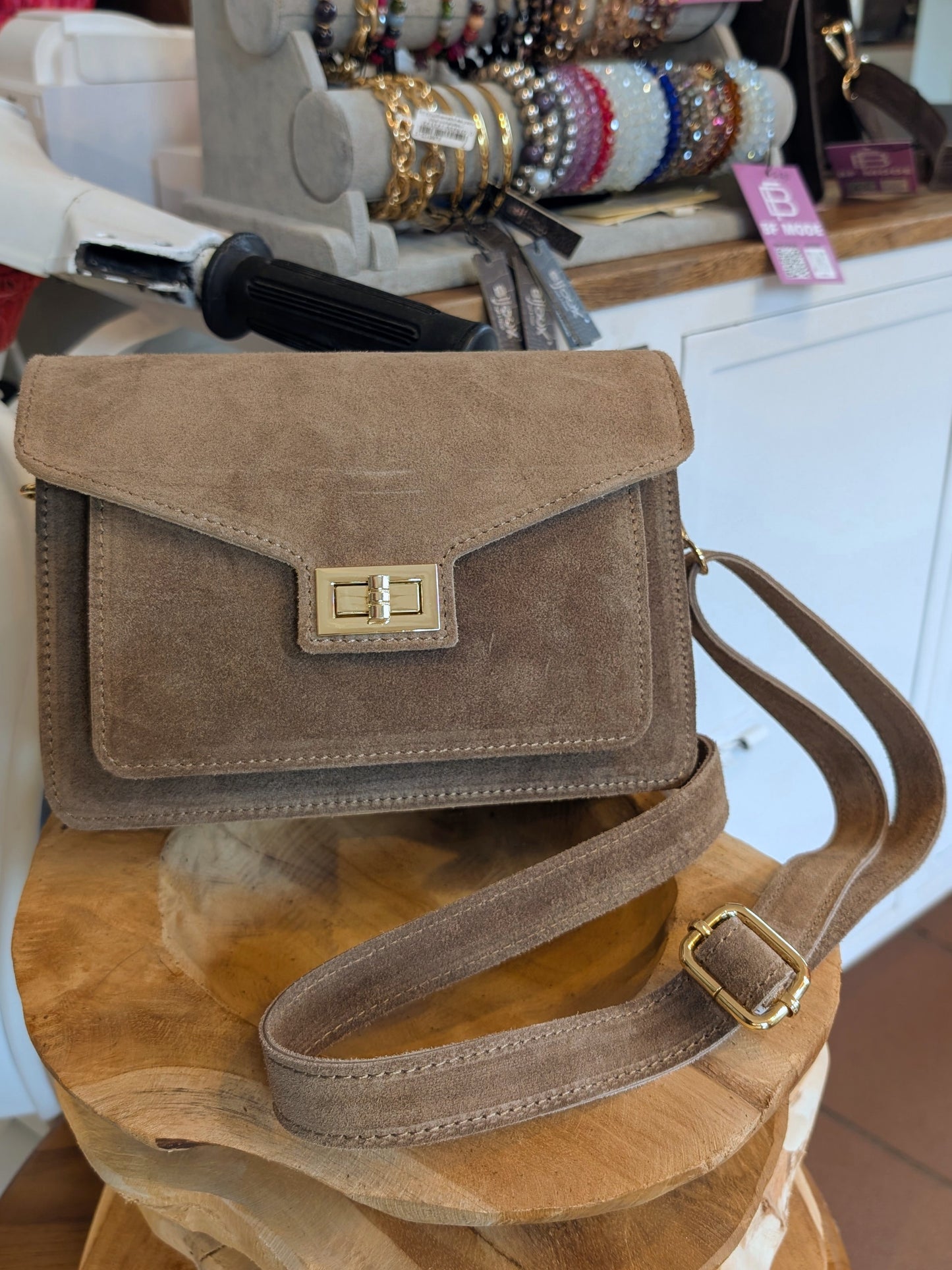 Die klassische Wildleder Cross-Body-Tasche in elegantem Taupe vereint zeitloses Design mit praktischer Funktionalität - perfekt für Alltag oder besondere Anlässe!