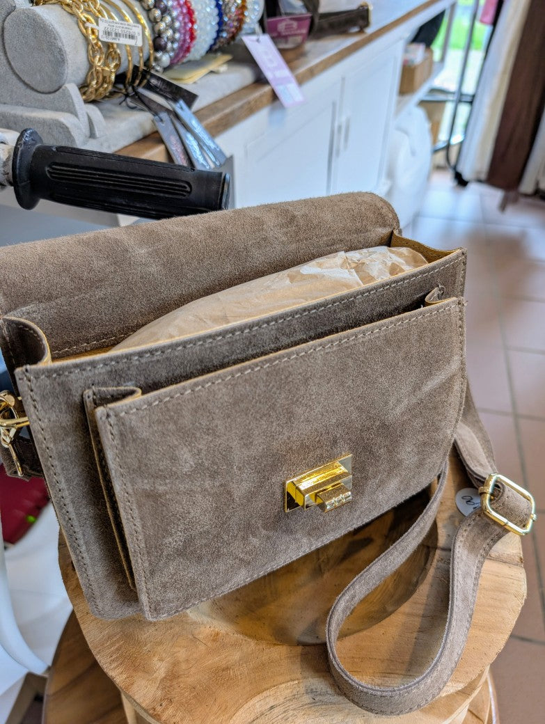 Die klassische Wildleder Cross-Body-Tasche in elegantem Taupe vereint zeitloses Design mit praktischer Funktionalität - perfekt für Alltag oder besondere Anlässe!