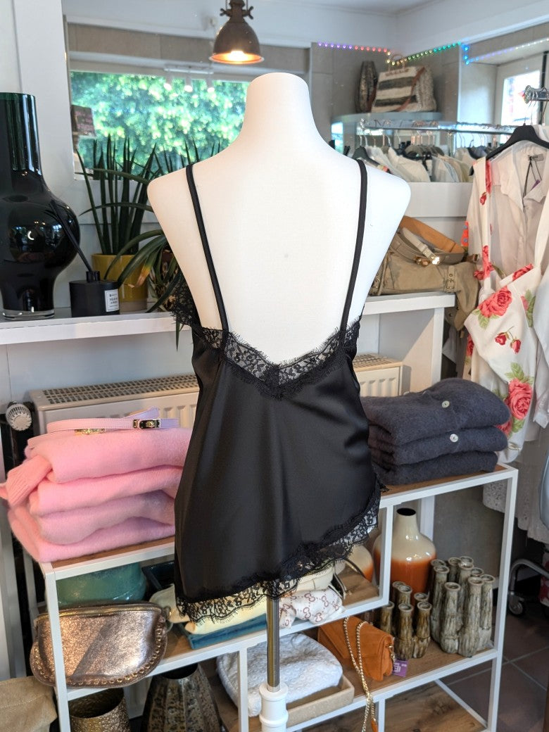 Elegantes seidiges asymmetrisches Satin-Top in klassischem Schwarz, verfeinert durch zarte schwarze Spitzendetails. Qualität und Komfort, den Sie verdienen!