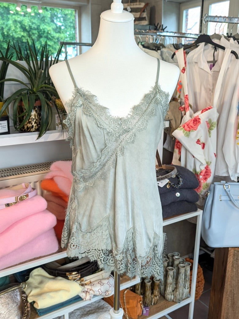 Elegantes seidiges asymmetrisches Viskose Satin Top in trendigem Grün, verfeinert durch zarte Spitzendetails. Qualität und Komfort, den Sie verdienen!