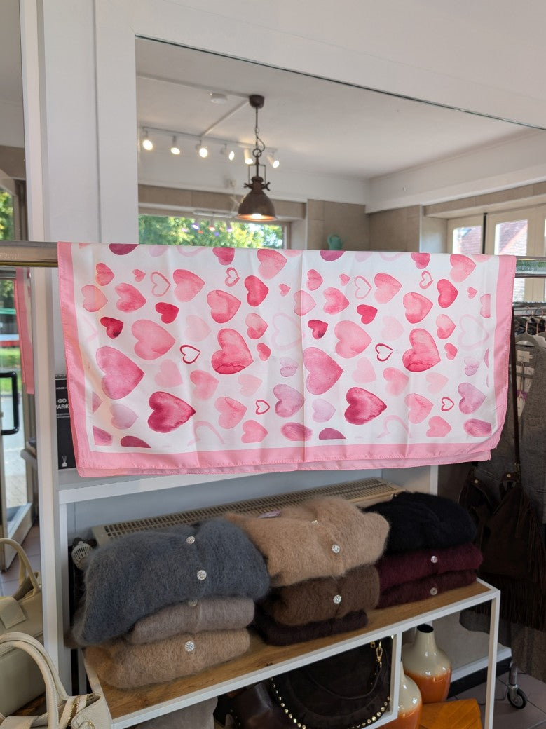 Das quadratische Viskose-Tuch in Weiß mit Herzen in Pink, Flieder und Rot setzt charmante farbenfrohe Akzente und verleiht jedem Outfit eine verspielte Note!