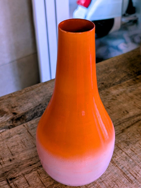 Die elegante Vase aus Metall in Flaschenform besticht durch sanften Farbverlauf von Orange zu Rosa und verleiht jedem Raum eine warme einladende Atmosphäre!