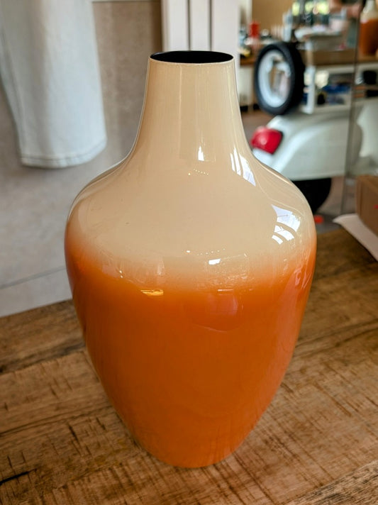 Die elegante Vase Größe M aus Metall besticht durch ihre Form und ihren sanften Orangeton mit Créme - verleiht jedem Raum eine warme einladende Atmosphäre!