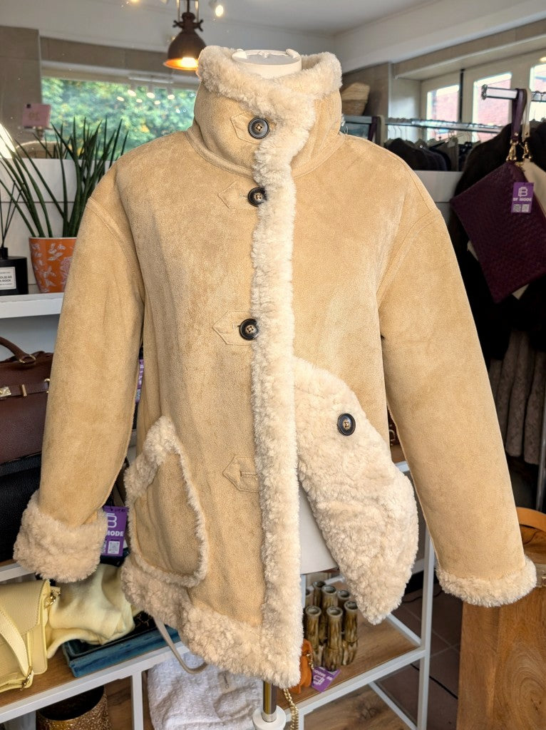 Die elegante kurze Wendejacke von Giovanni Paris verbindet mega weiche flauschige Stoffe mit zeitlosem Design in Beige und Wollweiß. Mit markantem hohen Kragen.