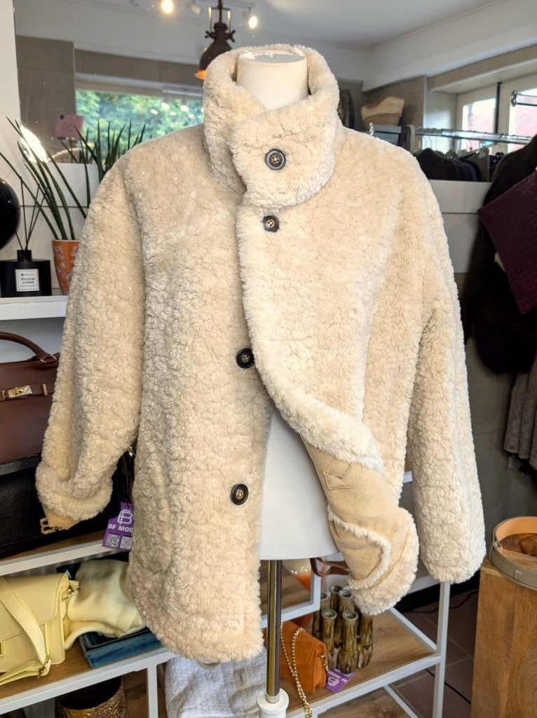 Die elegante kurze Wendejacke von Giovanni Paris verbindet mega weiche flauschige Stoffe mit zeitlosem Design in Beige und Wollweiß. Mit markantem hohen Kragen.
