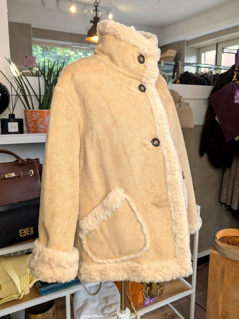 Die elegante kurze Wendejacke von Giovanni Paris verbindet mega weiche flauschige Stoffe mit zeitlosem Design in Beige und Wollweiß. Mit markantem hohen Kragen.