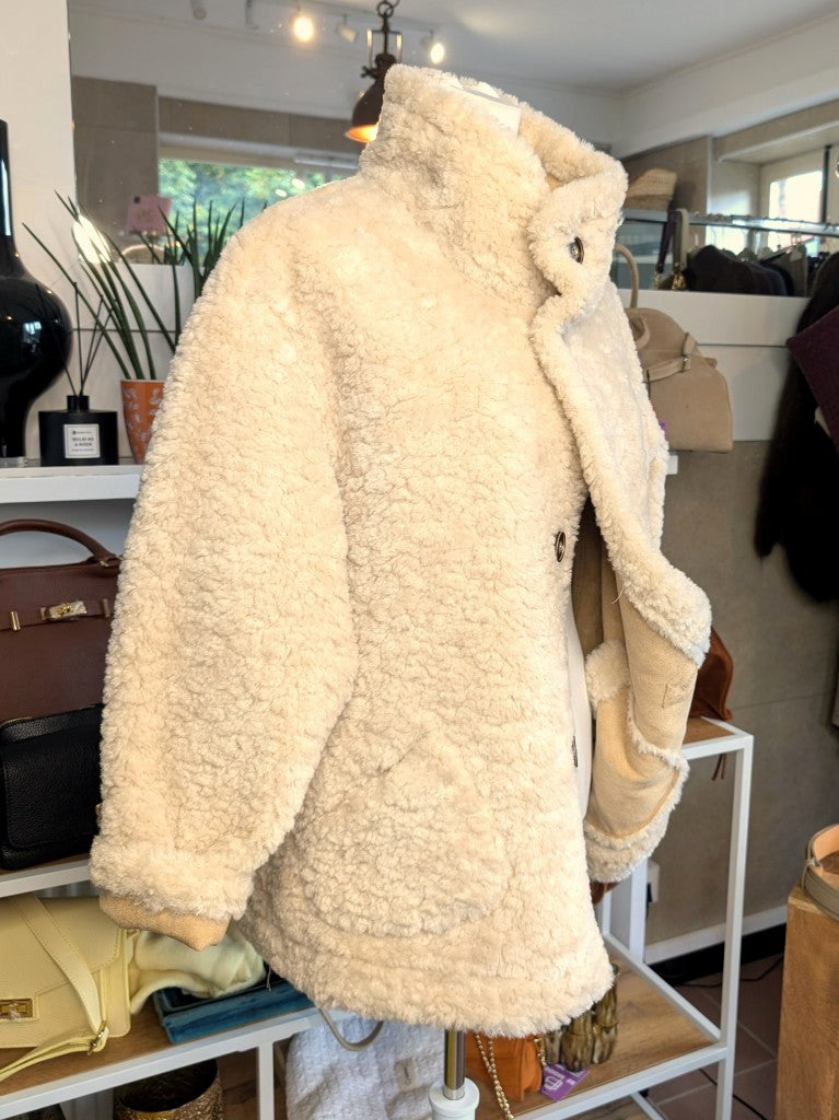 Die elegante kurze Wendejacke von Giovanni Paris verbindet mega weiche flauschige Stoffe mit zeitlosem Design in Beige und Wollweiß. Mit markantem hohen Kragen.