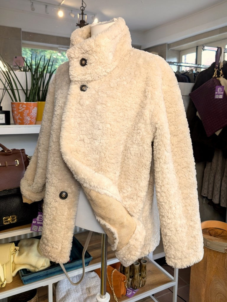 Die elegante kurze Wendejacke von Giovanni Paris verbindet mega weiche flauschige Stoffe mit zeitlosem Design in Beige und Wollweiß. Mit markantem hohen Kragen.