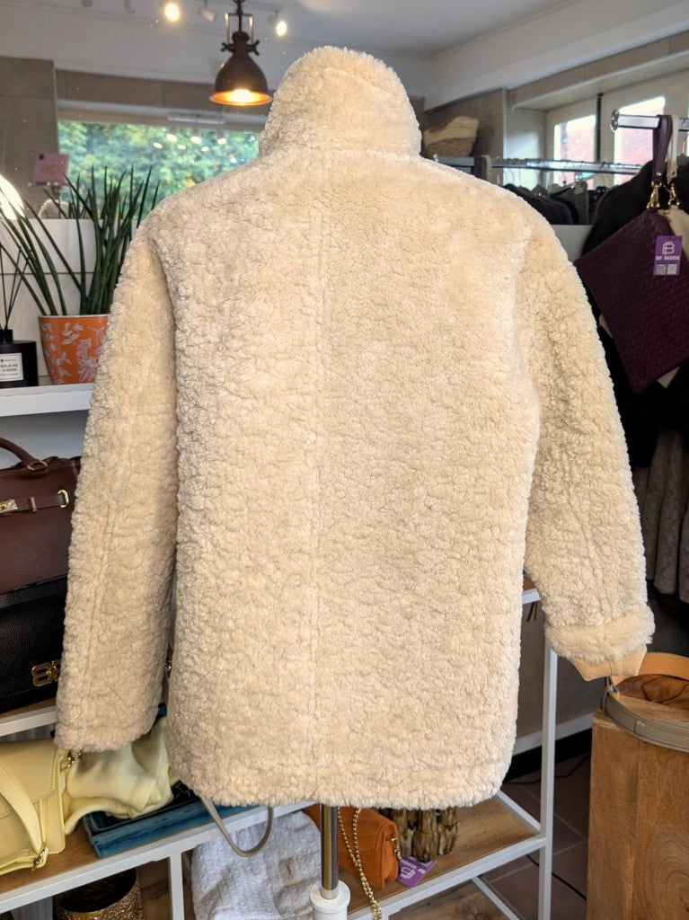 Die elegante kurze Wendejacke von Giovanni Paris verbindet mega weiche flauschige Stoffe mit zeitlosem Design in Beige und Wollweiß. Mit markantem hohen Kragen.