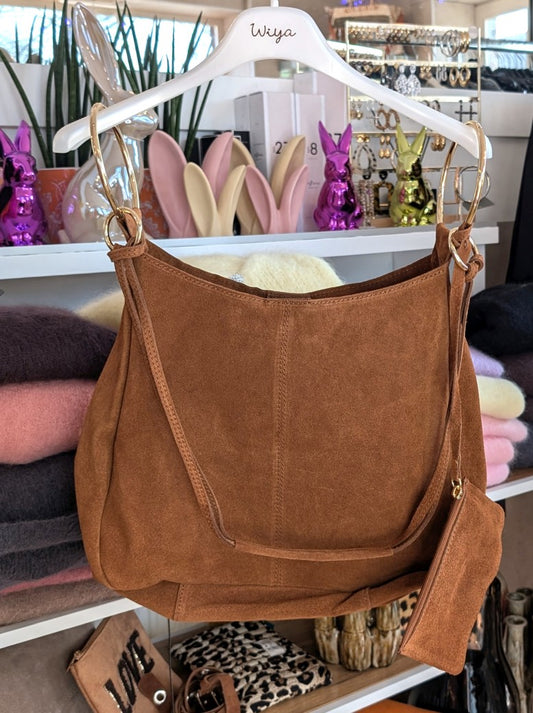 Die elegante Hobo Bag aus hochwertigem Wildleder in warmem Cognac-Ton mit herausnehmbarer Innentasche besticht durch goldenen Ösen und italienisches Handwerk.