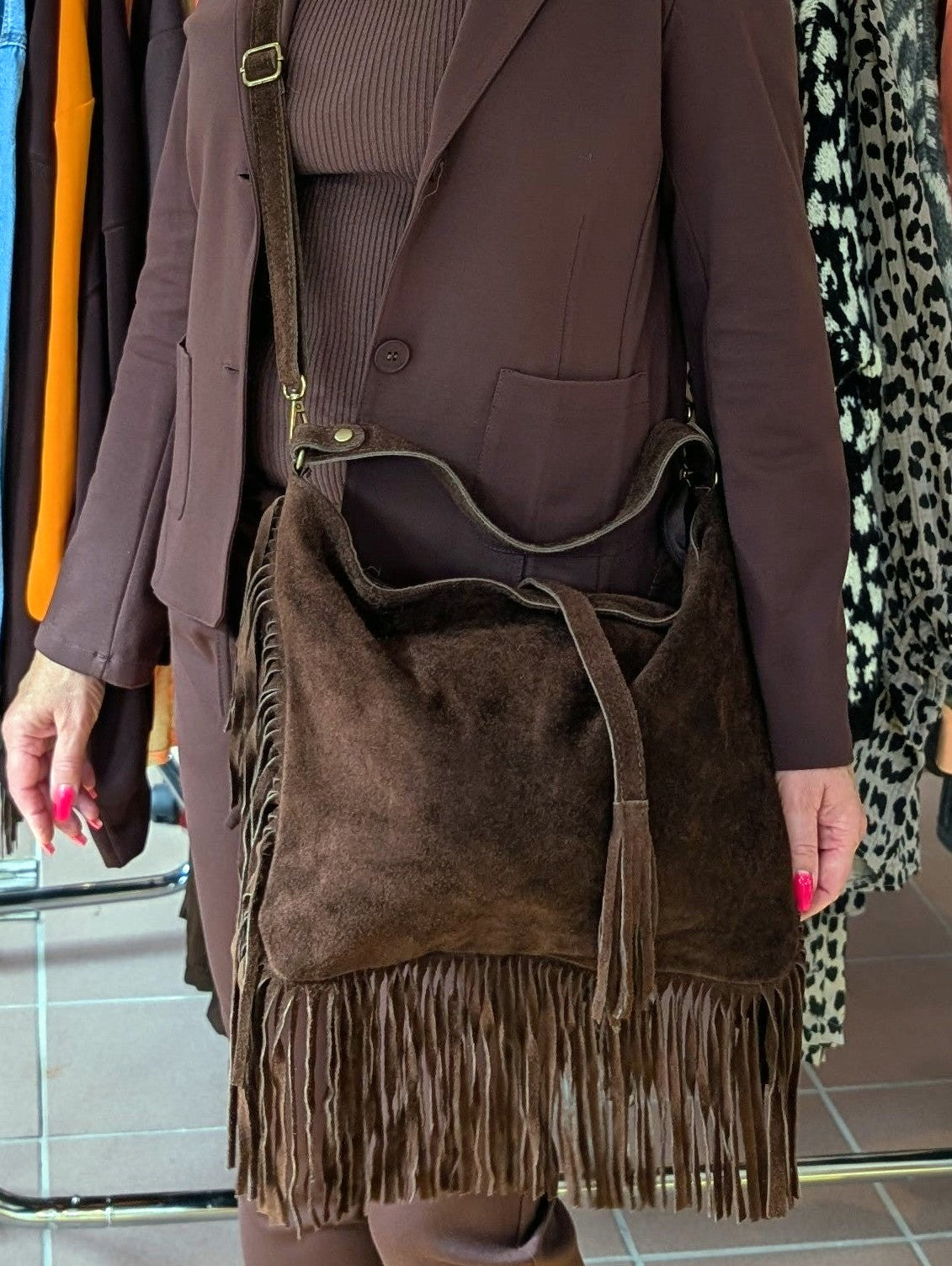 Die Wildledertasche in Coffee Braun überzeugt mit großzügigem Format, Schulterriemen, RV und stilvollen Fransen, die jedem Outfit eine trendige Note verleihen!