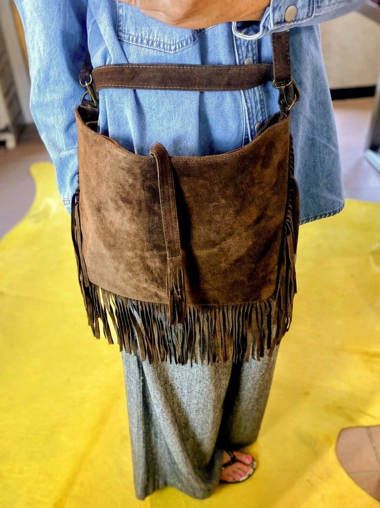 Die Wildledertasche in Coffee Braun überzeugt mit großzügigem Format, Schulterriemen, RV und stilvollen Fransen, die jedem Outfit eine trendige Note verleihen!
