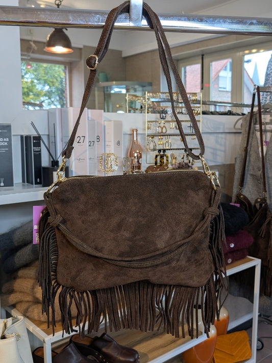 Die Wildledertasche in warmem Coffee Braun überzeugt mit großen Goldösen, Schulterriemen, RV und stilvollen Fransen - verleiht jedem Outfit eine trendige Note!