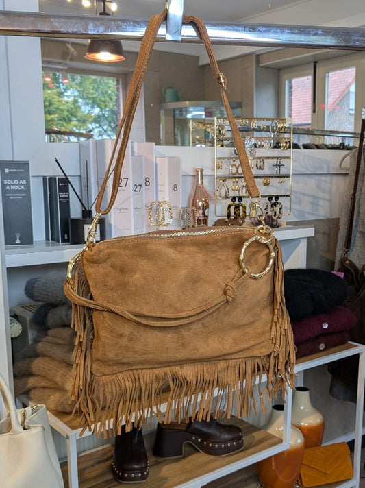 Die Wildledertasche in warmem Cognac überzeugt mit großen Goldösen, Schulterriemen, RV und stilvollen Fransen - verleiht jedem Outfit eine trendige Note!