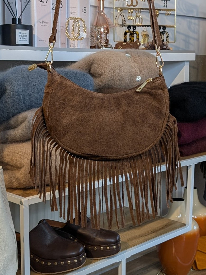 Die Wildledertasche in warmem Braun überzeugt mit Halbmond-Form, Schulterriemen, RV und stilvollen Fransen - verleiht jedem Outfit eine trendige Note!