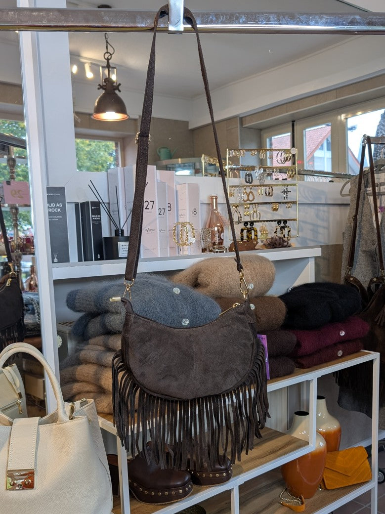 Die Wildledertasche in warmem Coffee Braun überzeugt mit Halbmond-Form, Schulterriemen, RV und stilvollen Fransen - verleiht jedem Outfit eine trendige Note!