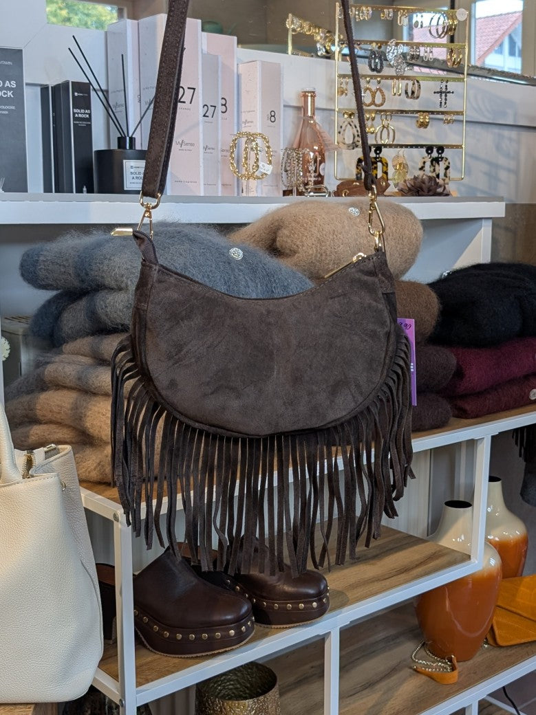 Die Wildledertasche in warmem Coffee Braun überzeugt mit Halbmond-Form, Schulterriemen, RV und stilvollen Fransen - verleiht jedem Outfit eine trendige Note!