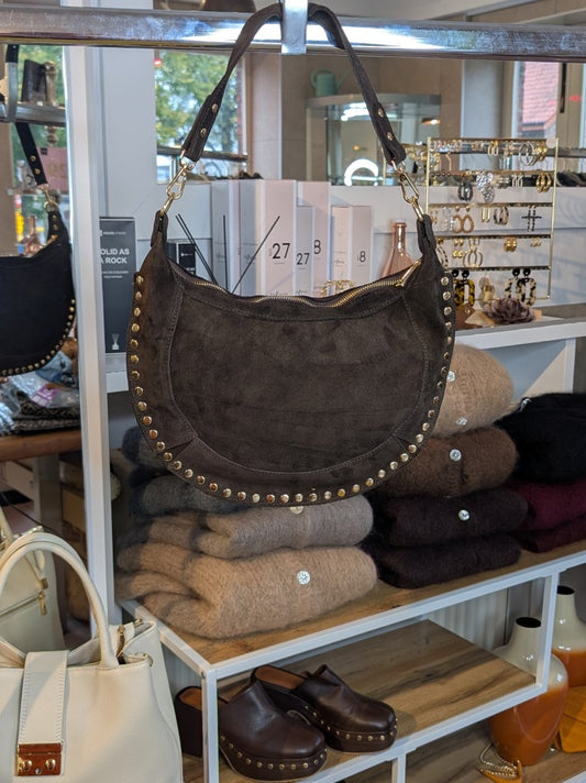 Die Halbmond Wildledertasche in Coffee Braun überzeugt mit mit Goldnieten, Schulterriemen und Reißverschluss - verleiht jedem Outfit eine trendige Note!