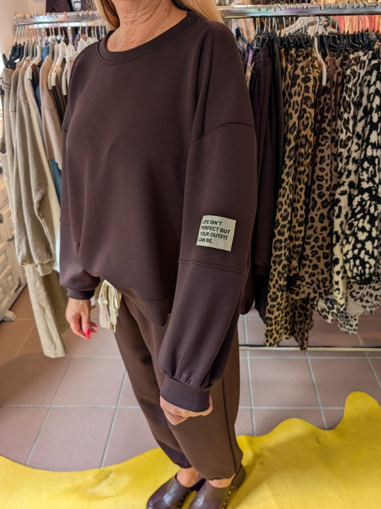 Das Set Sweatshirt & Hose in warmem Coffee Braun von LAVIA vereint Komfort und Stil mit dem Slogan "Life Isn't Perfect But Your Outfit Can Be" - fühl' Dich wohl!