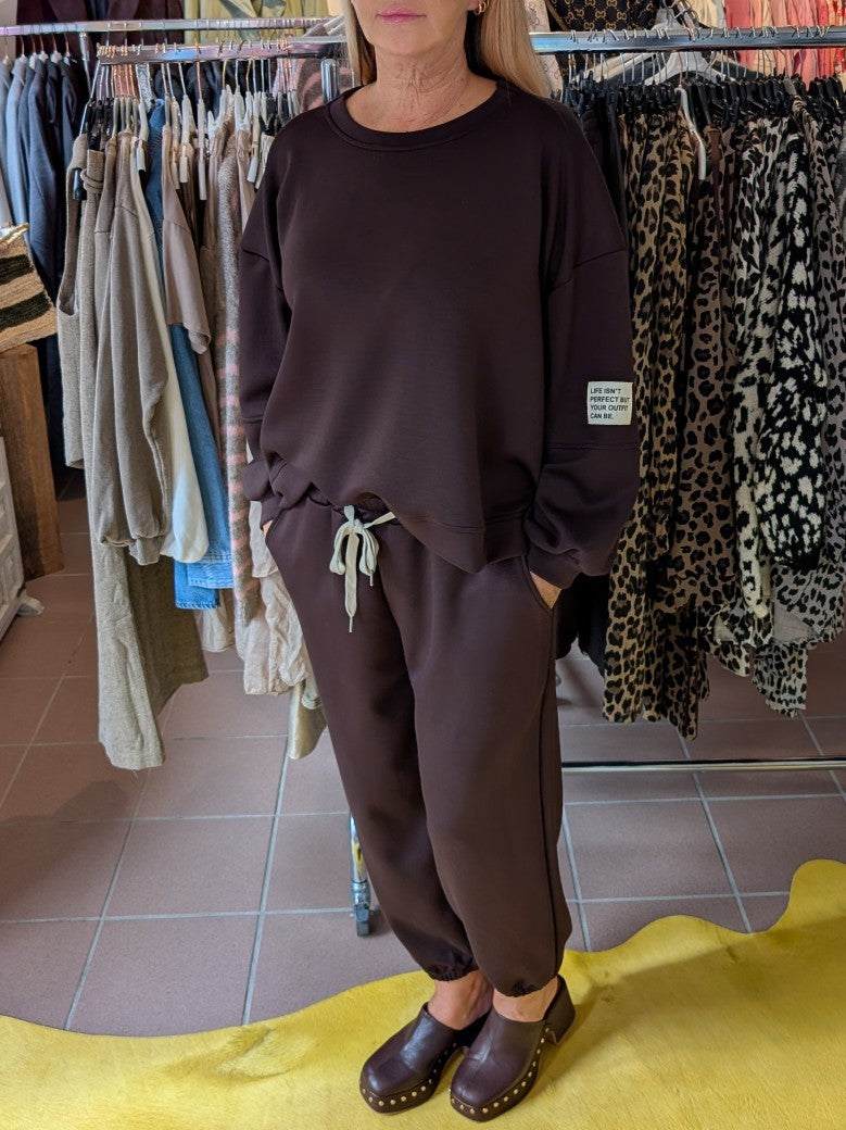 Das Set Sweatshirt & Hose in warmem Coffee Braun von LAVIA vereint Komfort und Stil mit dem Slogan "Life Isn't Perfect But Your Outfit Can Be" - fühl' Dich wohl!