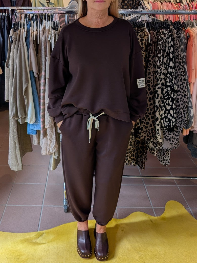 Das Set Sweatshirt & Hose in warmem Coffee Braun von LAVIA vereint Komfort und Stil mit dem Slogan "Life Isn't Perfect But Your Outfit Can Be" - fühl' Dich wohl!