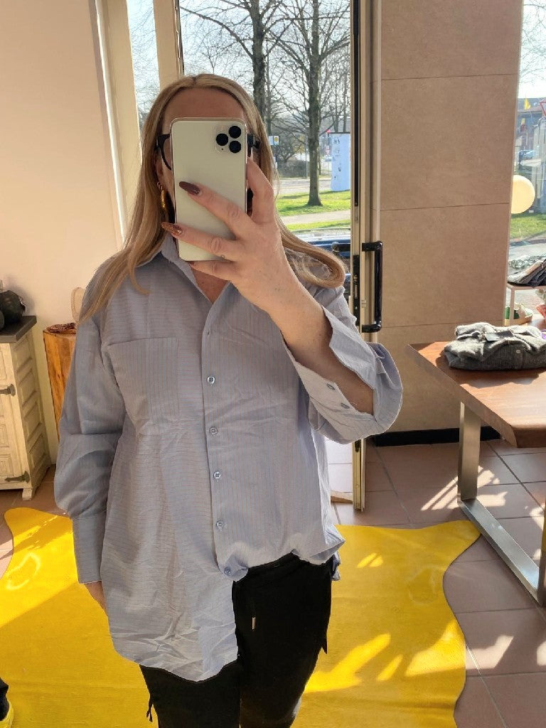 Bringen Sie etwas Farbe in Ihre Garderobe mit dieser Bluse in Hellblau mit grauen Streifen und farbigem Backprint Beach Party. Perfekt für Frühling/Sommer - echter Hingucker!