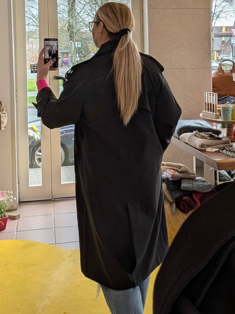 Genieße die hochwertige Verarbeitung und den stilvollen Look dieses eleganten Trenchcoat in klassischem Schwarz. Mit diesem langen Mantel bist Du immer gut angezogen!